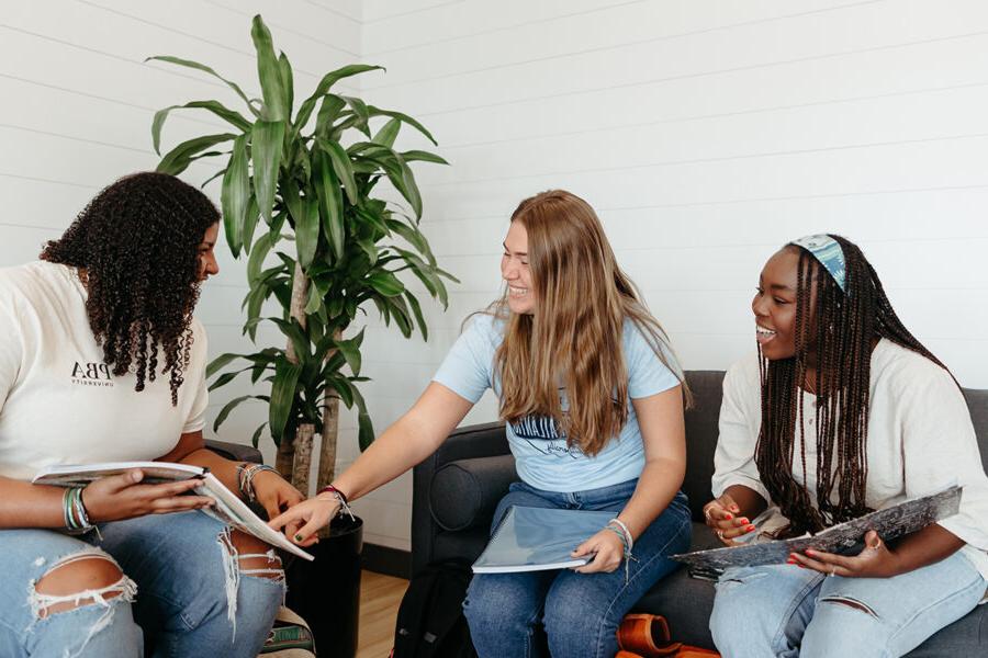 Three PBA students study together on campus.